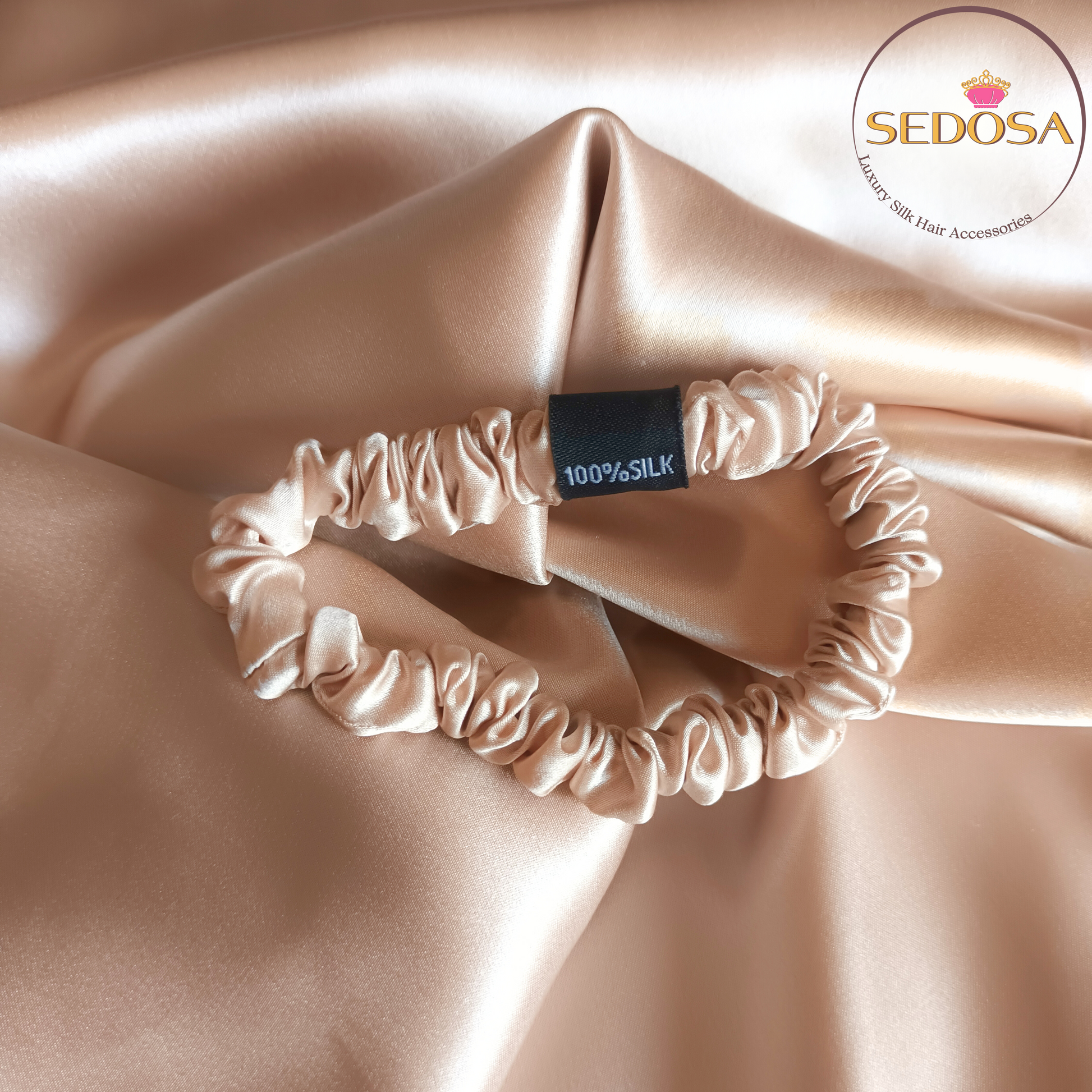 Caramel colour silk hair scrunchy sized skinny on a silk smooth surface with SEDOSA branding