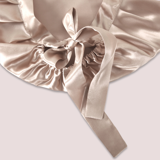 Image of a close-up of the sleeping hair bonnet, focusing on the adjustable ribbon (caramel colour)